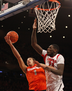 Michael Carter-Williams goes for a basket in the paint, but get's shot down by Louisville's 