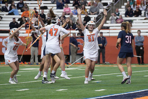 Syracuse players celebrate a goal against Connecticut on Feb. 9. The Orange scored 17 goals against Oregon on Sunday. 