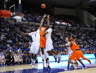 Syracuse forward Rakeem Christmas skies for a rebound against Connecticut forward Phillip Nolan.