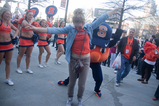 Sara Eckhardt, a fresman at Syracuse University, dances with Otto the Orange outside of The Hudson Grille in Atlanta. 