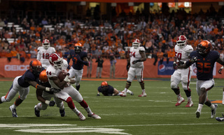 A pair of Orange defenders converge to bring down N.C. State's Marquez Valdes-Scantling while linebacker Dyshawn Davis comes over.