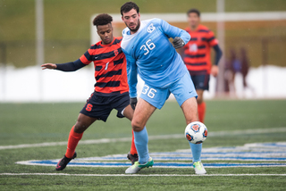 UNC's Tucker Hume protects the ball from Adams. 