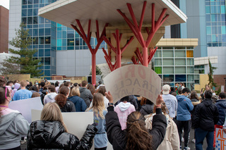 Dancers hold up signs for the children in front of Upstate Golisano as they crowd together and prepare to perform. 