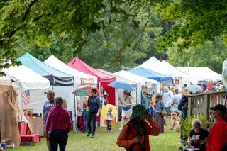 Families wander through the festival checking out all of the tents and vendors with products or goods they might want to buy in support of a local business. 